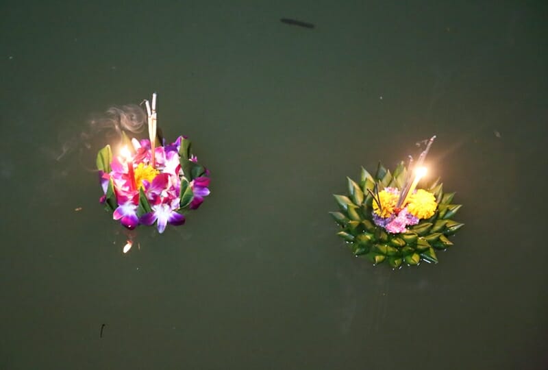 Krathongs floating down the river during Loy Krathong in Chiang Mai Thailand
