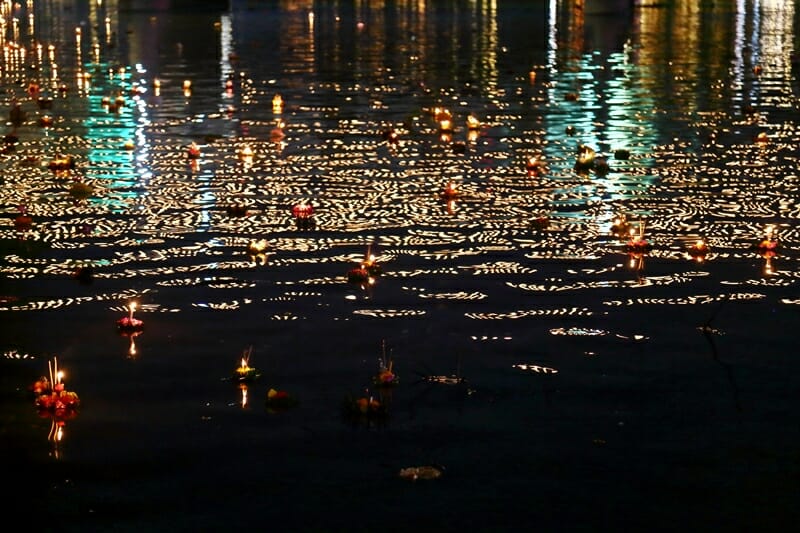 Krathongs floating down the river during Loy Krathong in Chiang Mai Thailand