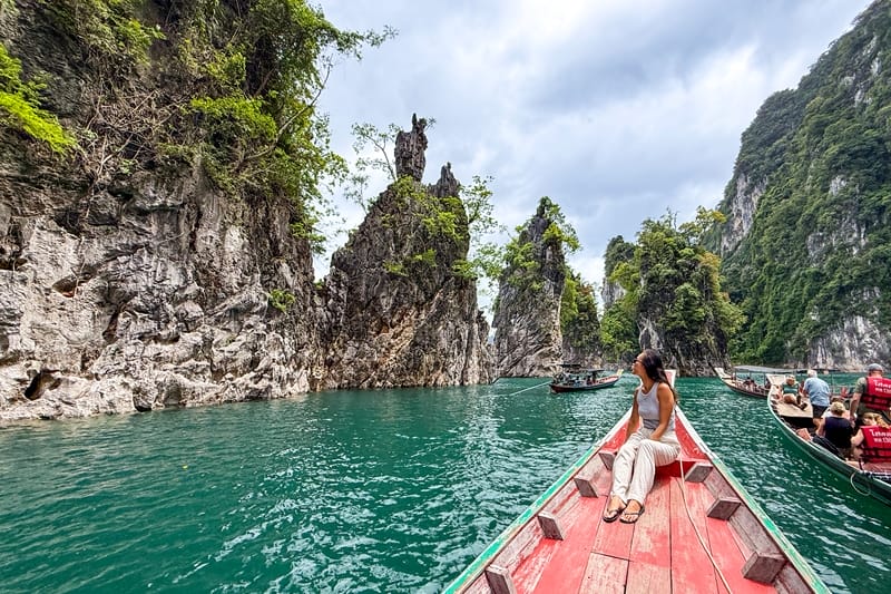 Woman sitting on a boat in Khao Sok National Park Cheow Lan Lake in Thailand