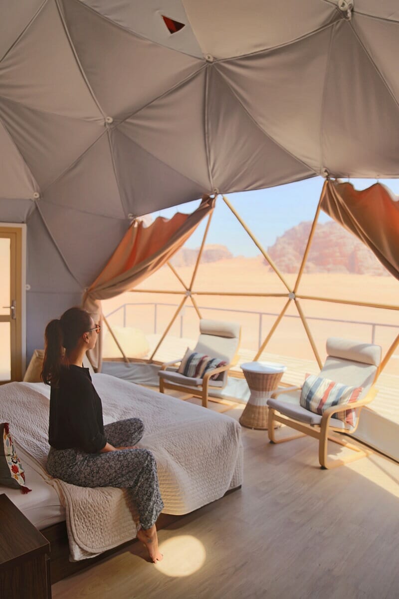 Woman sitting inside of bubble tent in Wadi Rum Jordan