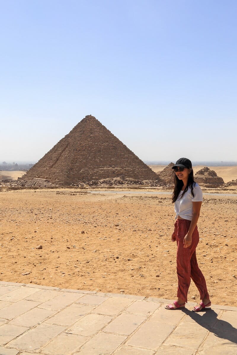 Woman standing in front of the Pyramids of Giza in Cairo Egypt