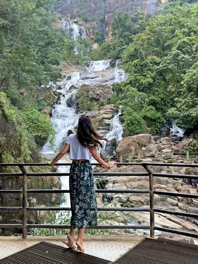 Woman standing in front of Ravana Falls in Ella Sri Lanka