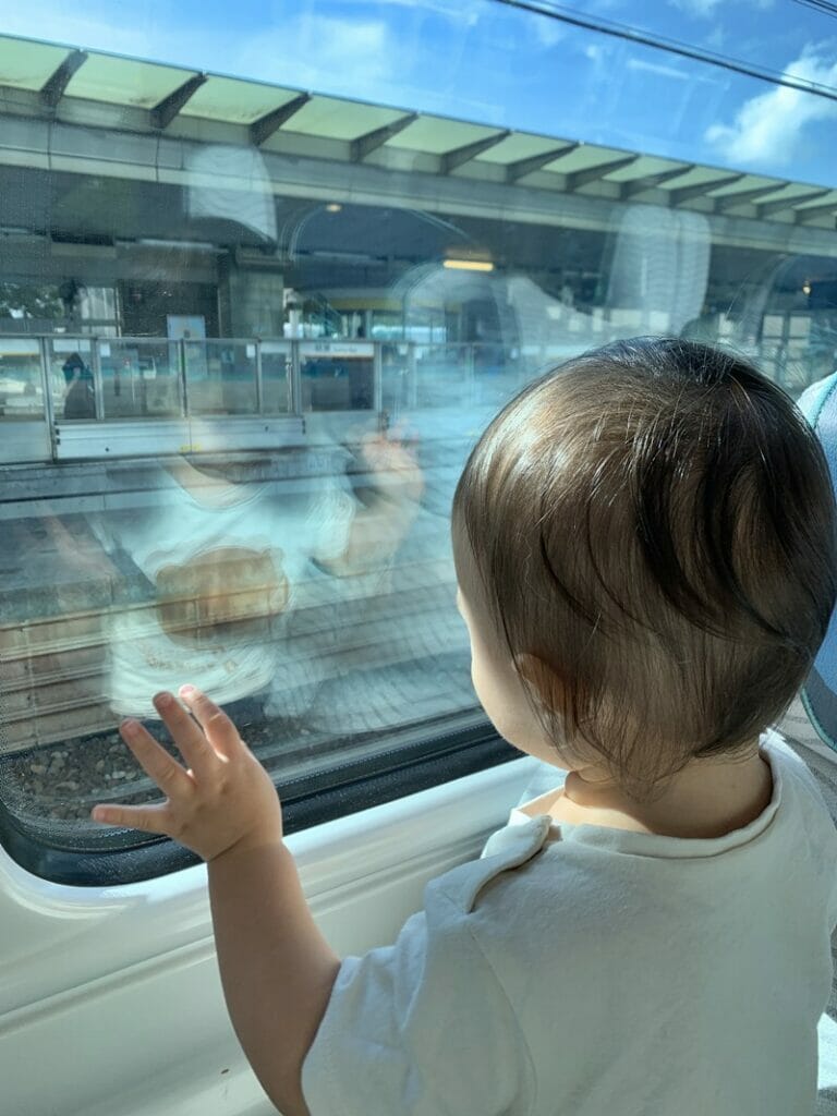 Toddler looking out of Hong Kong Airport Express window