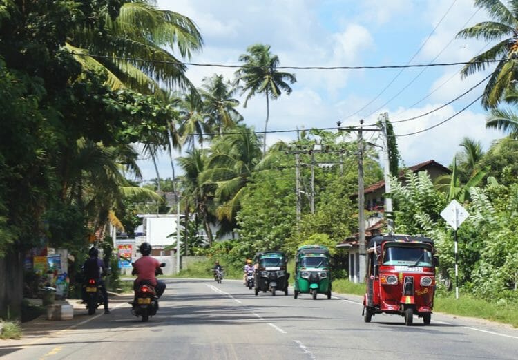 Tuk tuks driving on the main road in south Sri Lanka