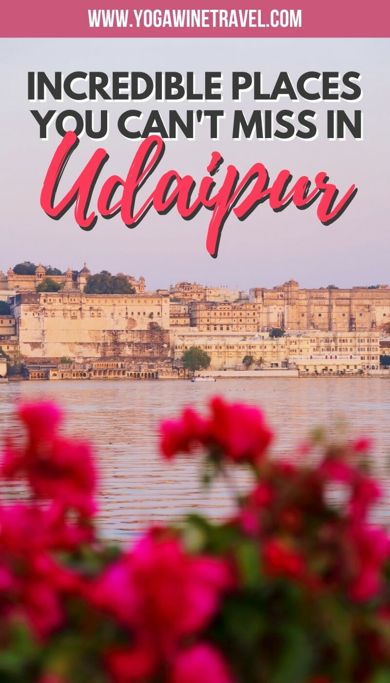 View of Lake Pichola and the City Palace in Udaipur in India with text overlay and flowers in the foreground