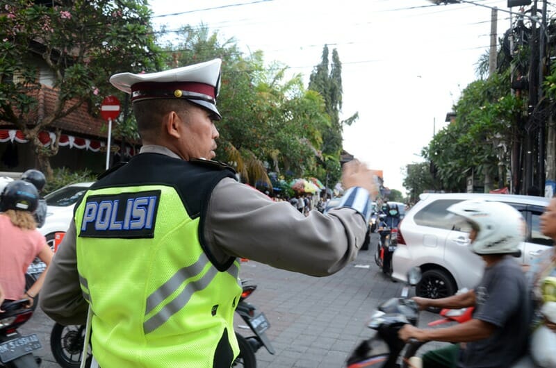 Road policeman controls the traffic of vehicles in Bali, Indonesia.