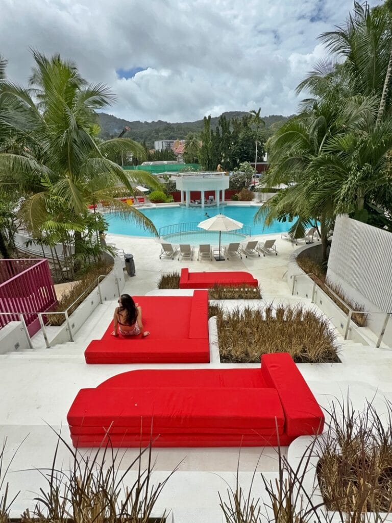 Woman sitting on red cushion at Terrace pool at Centara Karon Resort in Phuket Thailand