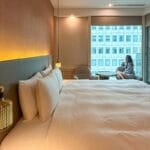 Woman starting out of bedroom window in a boutique hotel in Taipei Taiwan