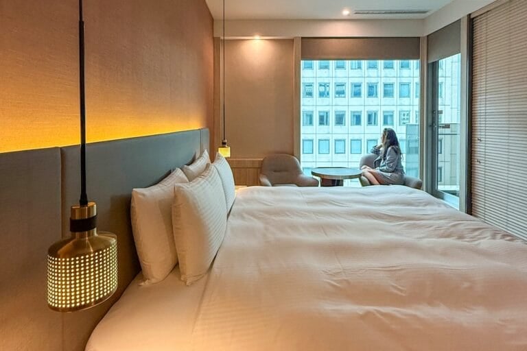 Woman starting out of bedroom window in a boutique hotel in Taipei Taiwan