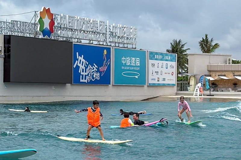 Child surfing beginner wave at wave pool in Hainan China