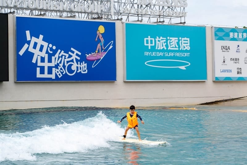Child surfing beginner wave at wave pool in Hainan China